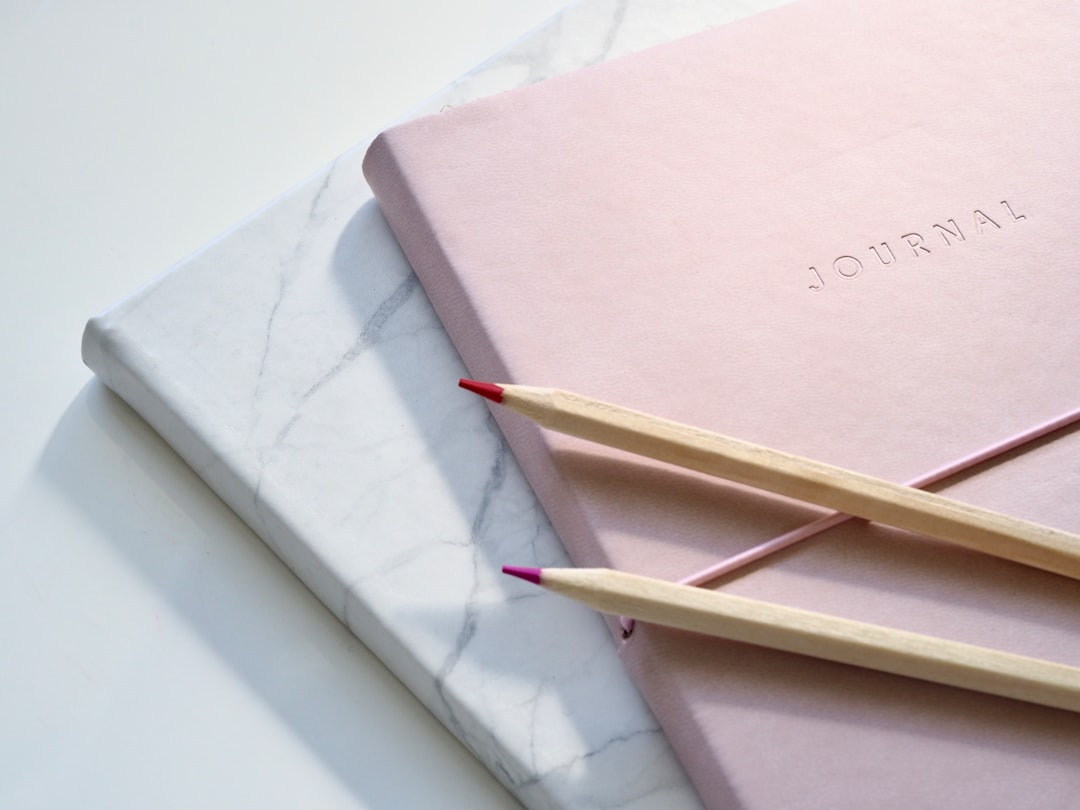 A training journal notebook and pencils — representing the practice of tracking rounds, combinations, and progress metrics that accelerates development and helps identify plateaus during your at-home heavy bag training program