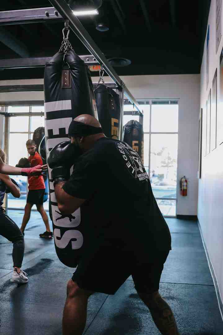 Member hitting a Legends Boxing heavy bag with full power and commitment